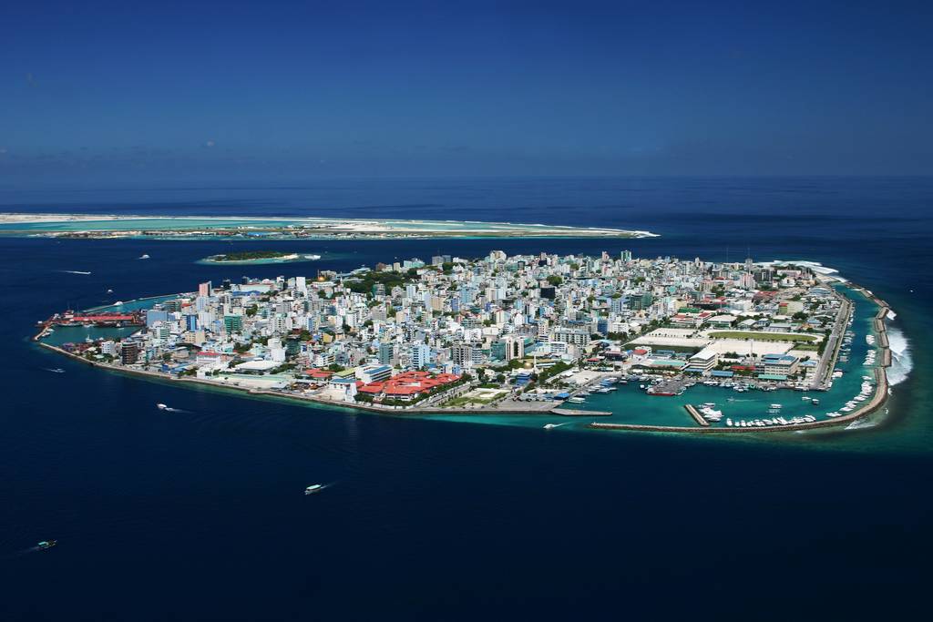Die Hauptstadt der Malediven, Malé, ist zu sehen. Es ist eine Stadt auf einer kleinen Insel, komplett vom Ozean umgeben.