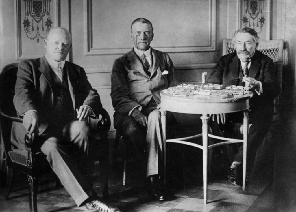 Stresemann, Chamberlain und Briand sitzen in gemeinsamer Runde