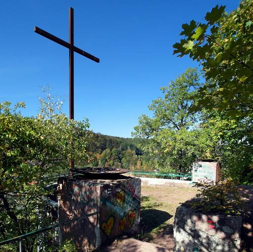 Quellenberg-Denkmal: Ein großes Eisenkreuz flankiert von zwei Feuerschalen