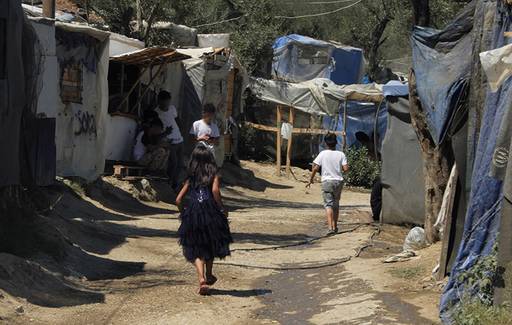 Einige Kinder gehen durch das Flüchtlingslager in der Nähe der griechischen Stadt Moria. Die Behausungen sehen nicht sehr stabil aus.
